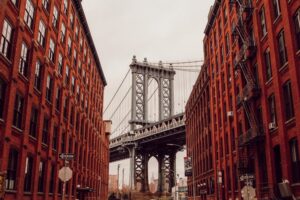 a view of the Brooklyn Bridge between two brick buildings in Dumbo.